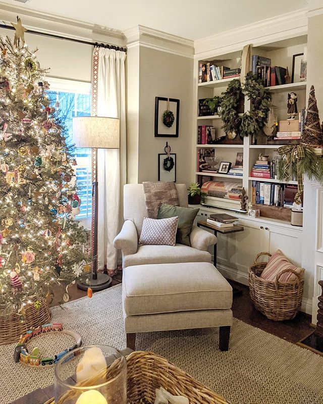 a living room with a christmas tree in the corner and other decorations on the shelves