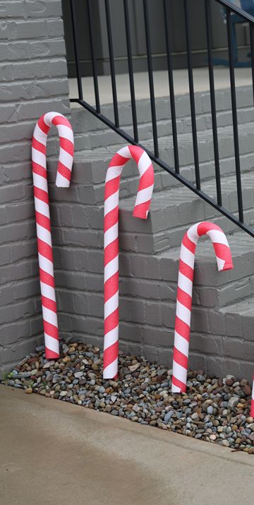 some candy canes are sitting on the ground next to a brick wall and stairs