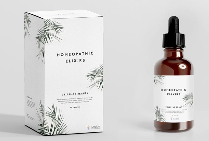 a bottle of homeopatic elixitors next to a box on a white background