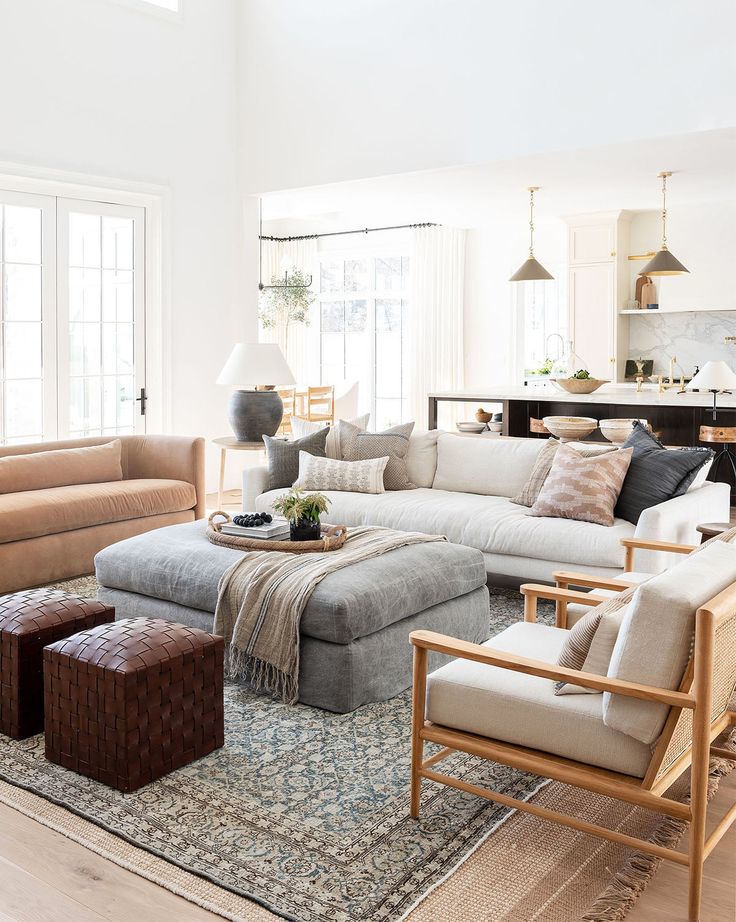 a living room filled with furniture and a large rug on top of a hard wood floor