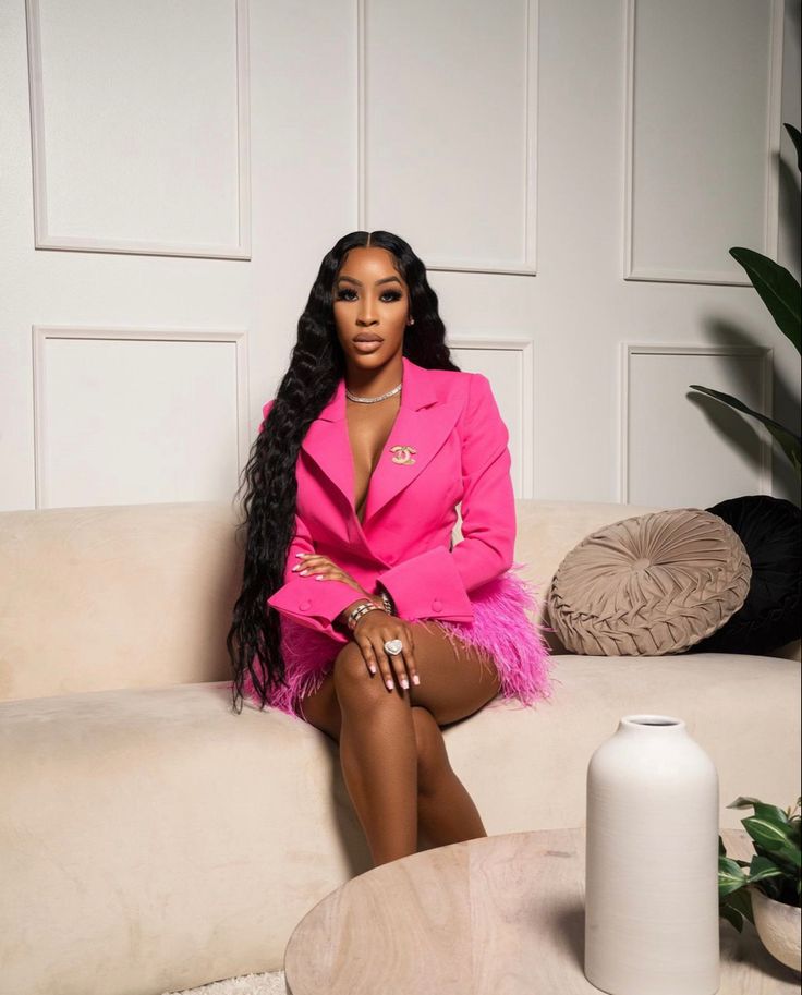 a woman in a pink suit sitting on a couch