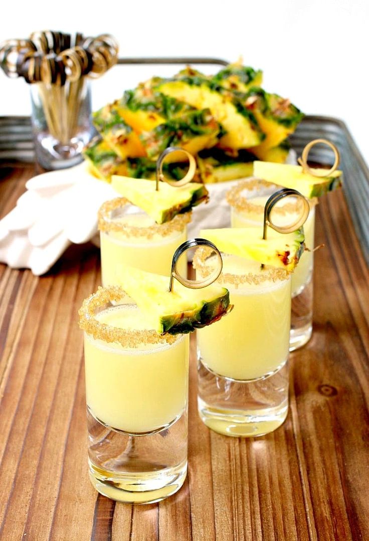 pineapple margaritas are served in glasses on a tray