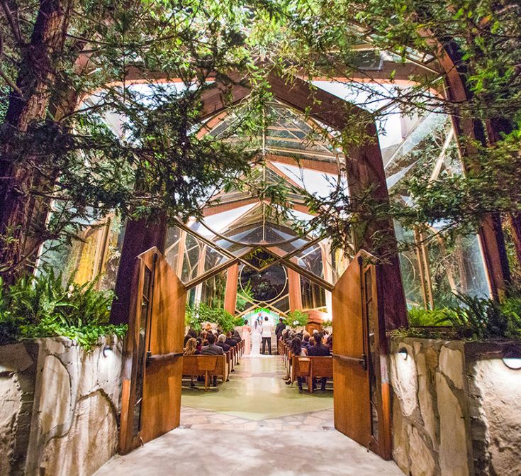 the inside of a building with trees and people sitting at tables in front of it