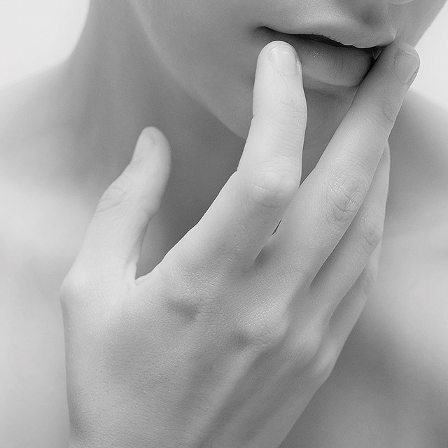 black and white photograph of a woman's face with her hand on her chin