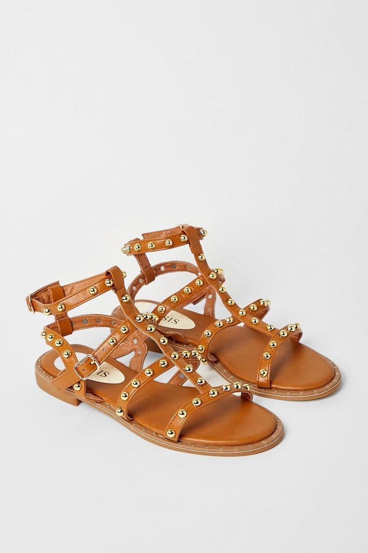 Gladiator-inspired faux leather sandals with studded straps Multiple crisscross straps with gold-tone stud embellishments Flat sole for all-day comfort Adjustable ankle strap with buckle fastening Versatile tan hue to complement warm weather ensembles Exude feminine flair with these eye-catching gladiator sandals from Oasis. The flat sole offers a comfortable stride, while the studded straps radiate a touch of edginess. Style them with a floral sundress and denim jacket for a casual daytime look, or pair them with tailored shorts and a camisole for an effortless evening ensemble. These sandals are perfect for family gatherings, shopping trips, or any casual warm-weather event. Gladiator Flats, Flat Gladiator Sandals, Sequin Outfit, Oasis Fashion, Tailored Shorts, Floral Sundress, Boots For Sale, Family Gatherings, Ankle Strap Sandals