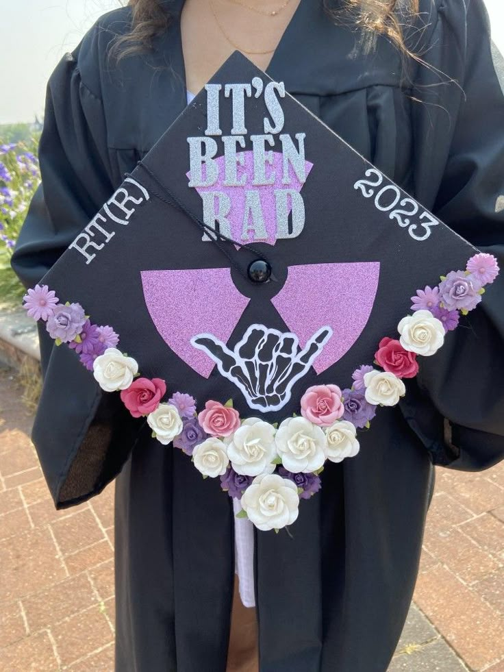 a person wearing a graduation cap that says it's been bad with flowers on it