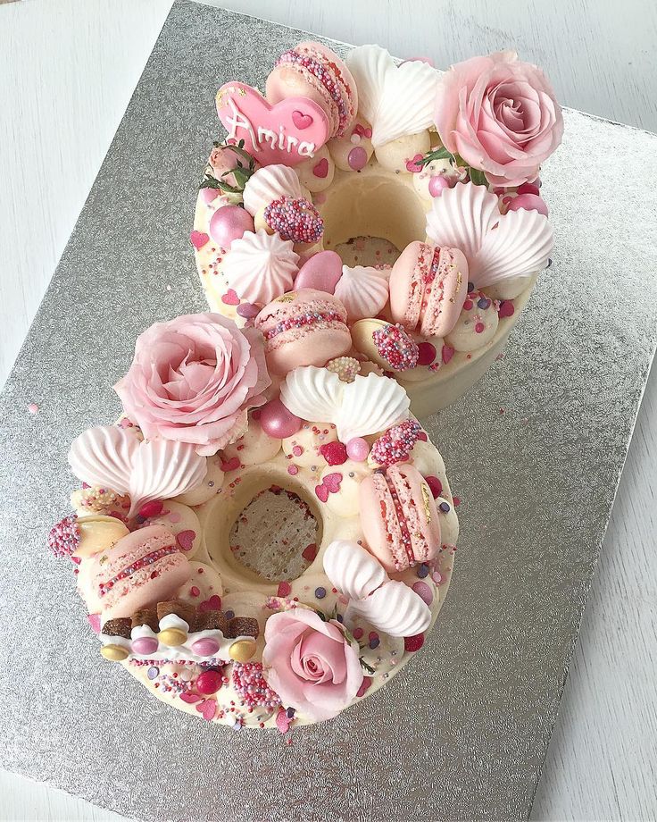 two cakes decorated with pink flowers and seashells