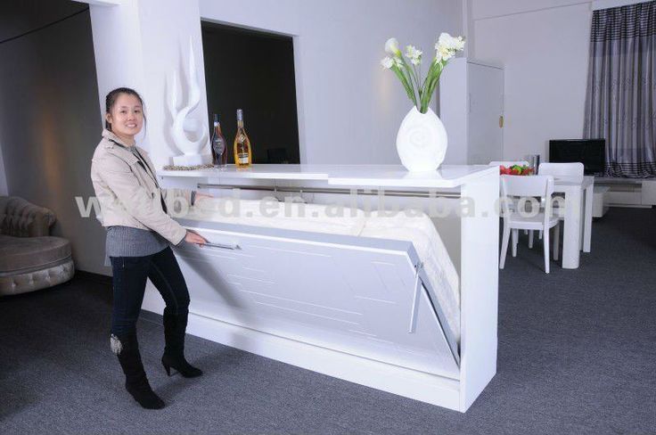 a woman standing next to a white counter in a living room