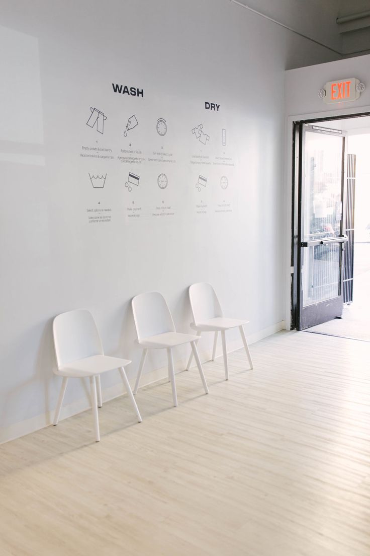 three white chairs are lined up against the wall