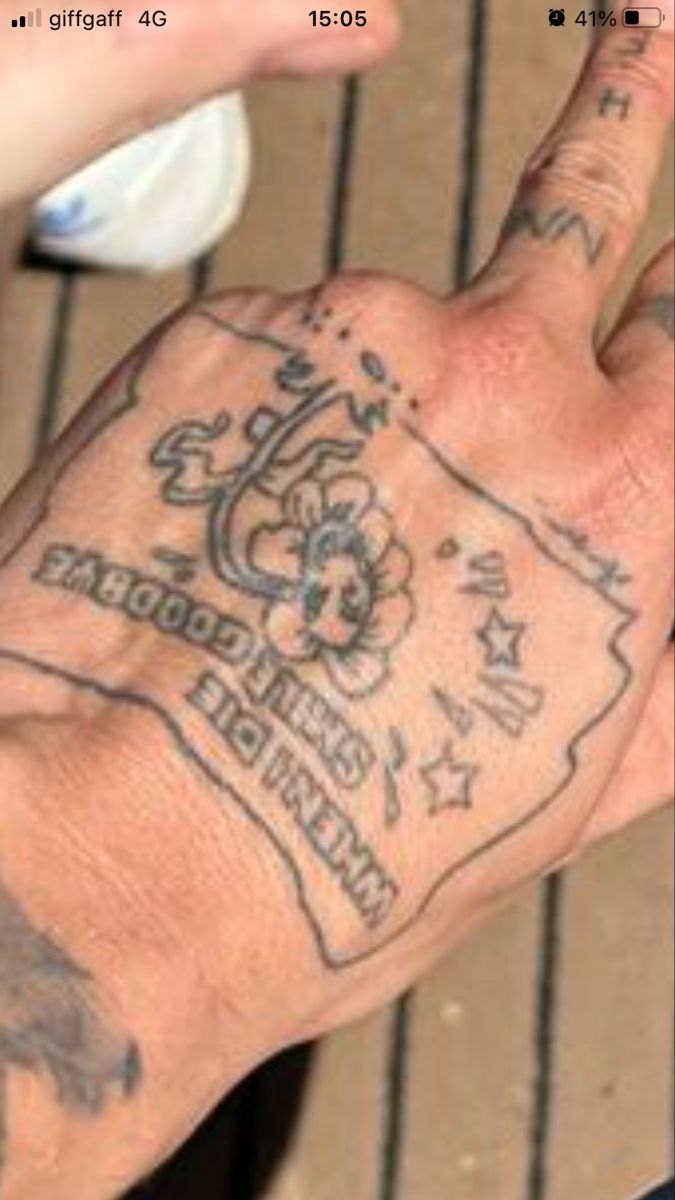 a person's hand with tattoos on it and the number one in front of them