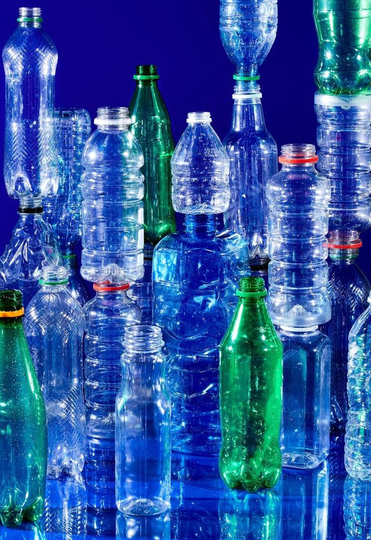 many empty plastic bottles are lined up in the same pattern as each other on a blue background