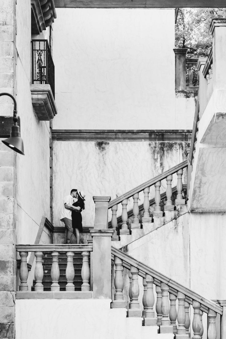 a man sitting on top of a set of stairs next to a stair case and lamp