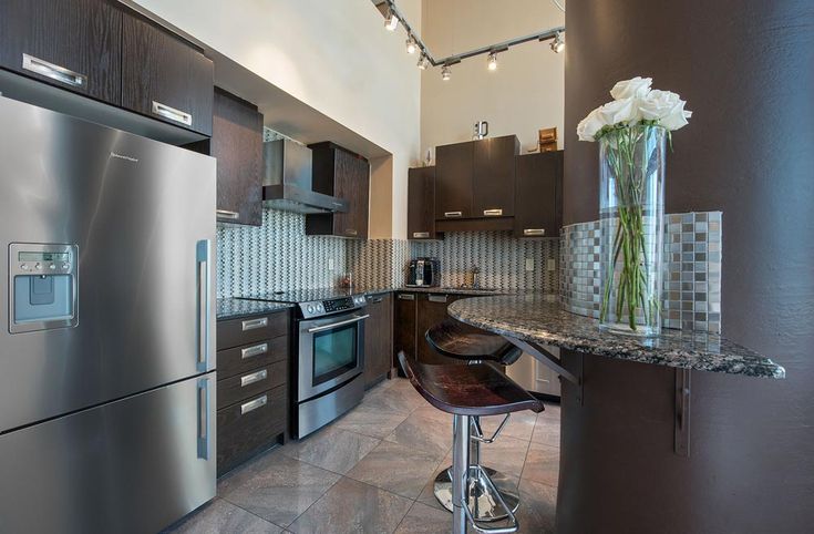 a modern kitchen with stainless steel appliances and granite counter tops