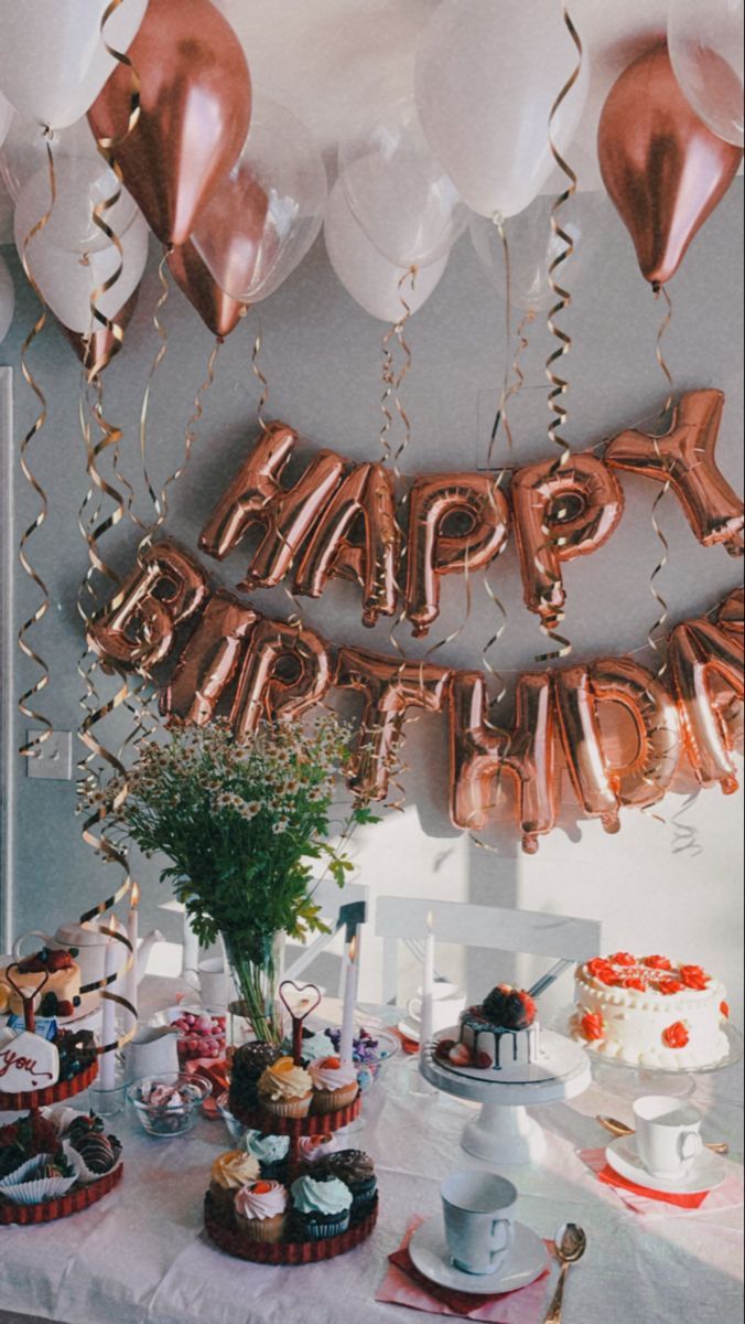 a table topped with lots of cake and balloons