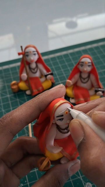 a person is holding some small figurines on a table