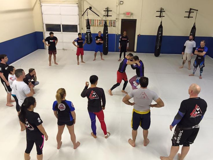 a group of people standing around each other in a gym