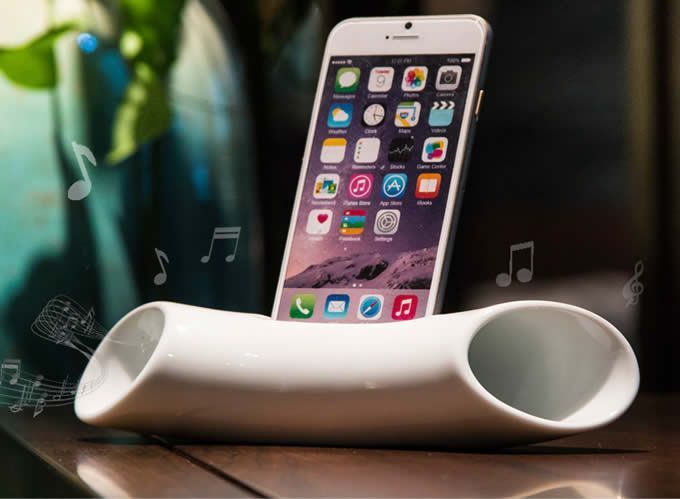 an iphone is sitting in a cup on a table with music notes coming out of it