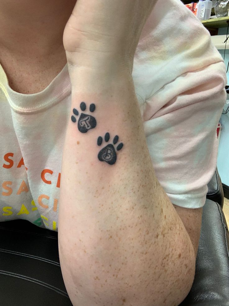 a person with a dog paw tattoo on their left arm, sitting in an office chair