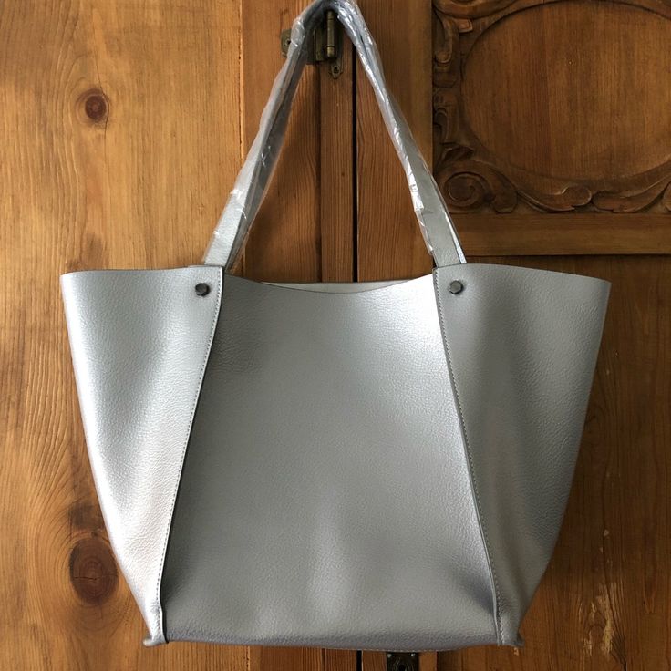 This Neiman Marcus Bag Is The Perfect Size And Color. Elegant And Fun, Goes With Everything. New, No Tags, Still Has The Plastic Protective Wrap On The Handles. Man Made Material, Not Leather. Silver Tote Shoulder Bag For On-the-go, Gray Shoulder Bag Satchel For Shopping, Everyday Silver Bags With Double Handle, Everyday Use Bucket Bag With Silver-tone Hardware, Daily Use Tote Shoulder Bag With Silver-tone Hardware, Silver Tote Bag For Everyday Use, Silver Tote Bag For Daily Use, Silver Satchel For Everyday Use, Daily Use Double Handle Shoulder Bag With Silver-tone Hardware