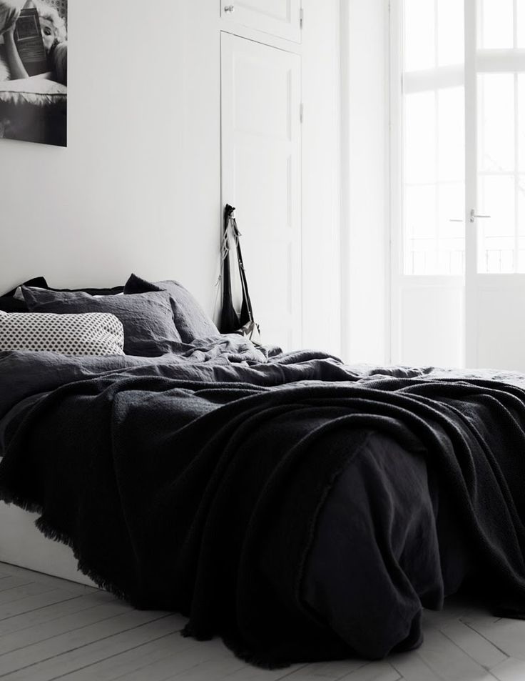 a black and white photo of an unmade bed