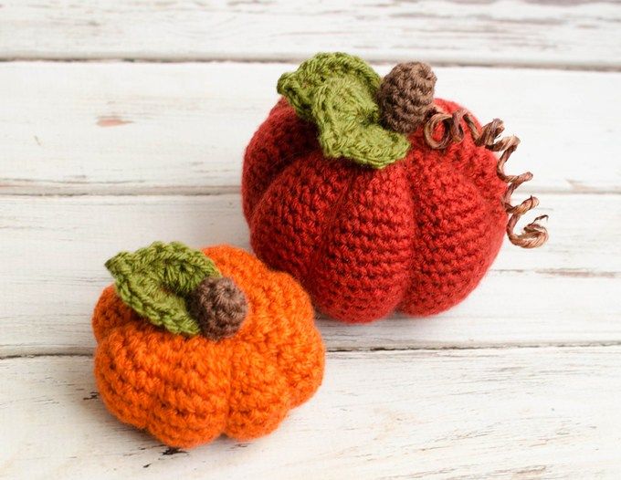 two crocheted pumpkins sitting next to each other