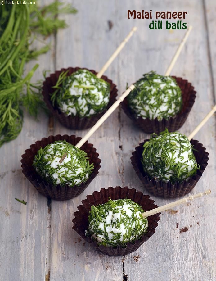 four chocolates with white sprinkles on them sitting on a wooden table