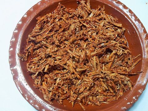 a brown plate filled with lots of food on top of a white tablecloth covered table