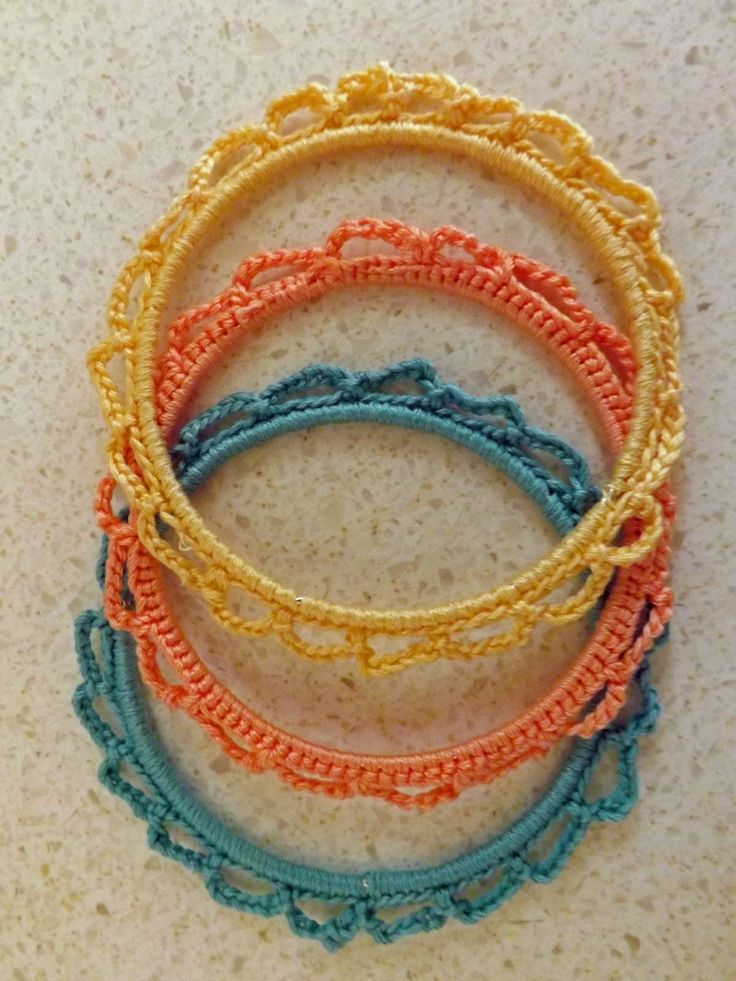 four different colored bracelets sitting on top of a table