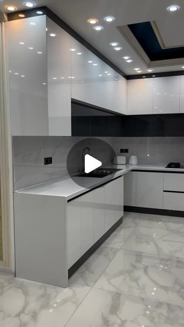 an empty kitchen with white cabinets and black counter tops is seen in this image from the video