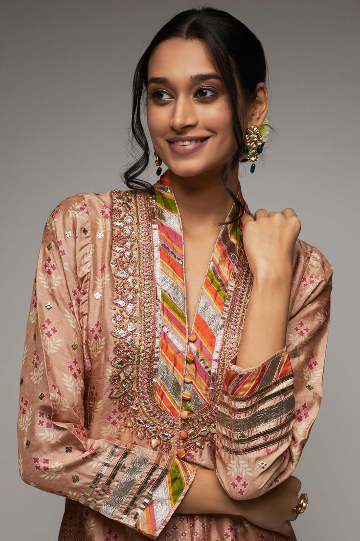 Editor's Note Elevate your style with the Tilla jacket-style tunic, paired with embroidered cutwork palazzo pants. This exquisite ensemble features a mix of a strong floral butta and a geometric jaal pattern, delicately enhanced with tiny motifs in silver foil. The neckline is beautifully enhanced with dori and sequins zardosi embroidery, adding a touch of opulence and glamour. Fabric: Tunic: tussar silk, palazzo: cotton Color: Pink Component: Tunic and palazzo Occasion: Festive Note: Product co Transitional Anarkali Palazzo Set With Floral Embroidery, Chanderi Palazzo Set With Resham Embroidery And Long Sleeves, Floral Embroidery Pant Set For Festivals, Festive Multicolor Embroidered Sharara, Chanderi Pant Set With Floral Embroidery, Designer Festive Pant Set With Floral Embroidery, Festivals Long Sleeve Palazzo Set With Floral Embroidery, Long Sleeve Floral Embroidery Palazzo Set For Festivals, Festival Long Sleeve Palazzo Set With Floral Embroidery