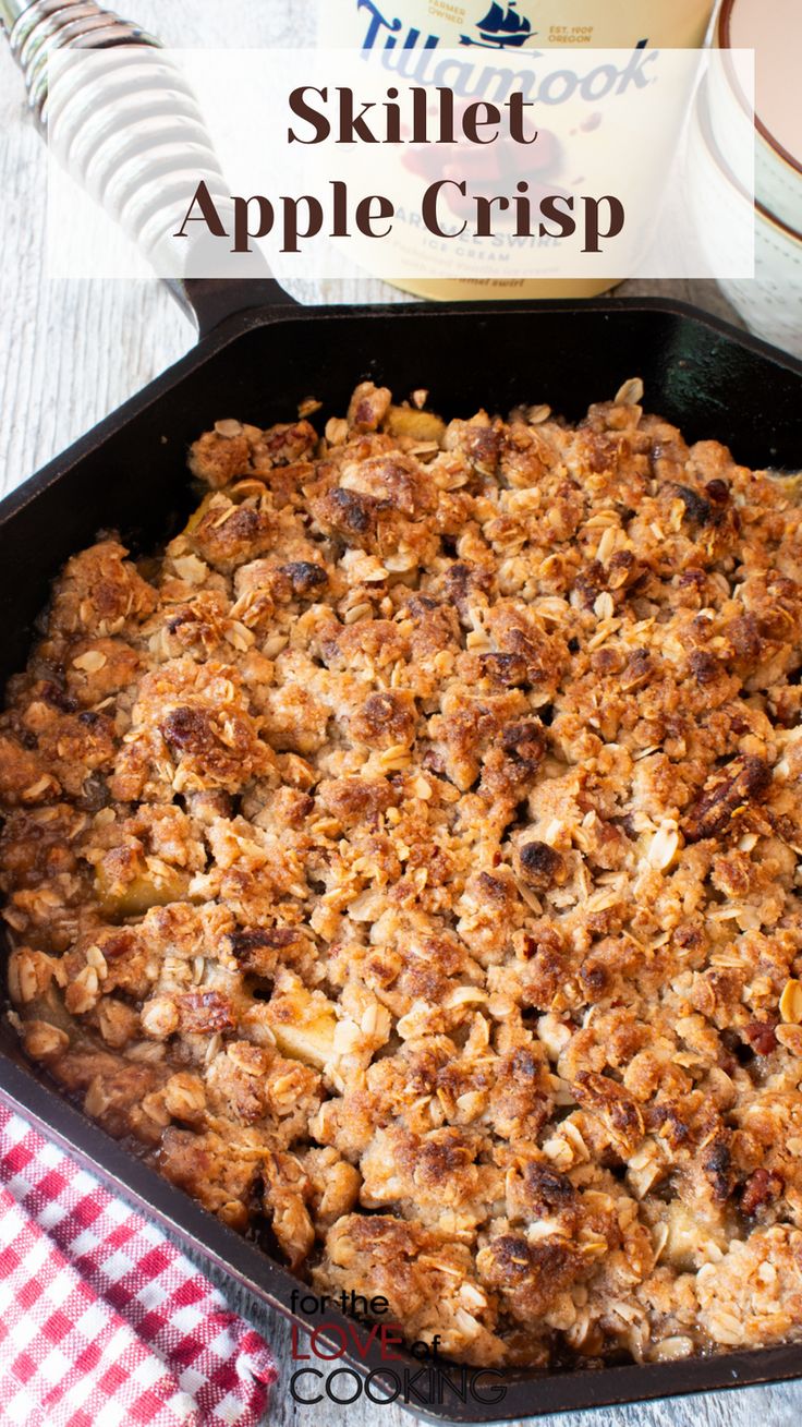 a skillet filled with apple crisp on top of a checkered table cloth next to an