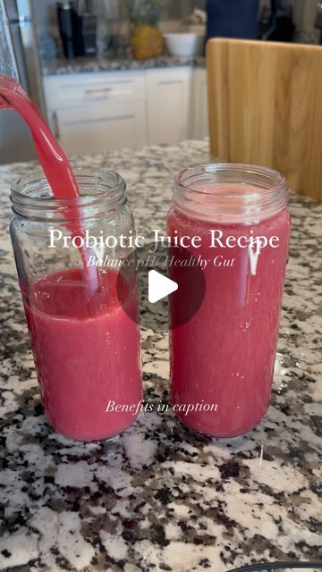 two jars filled with pink liquid on top of a counter