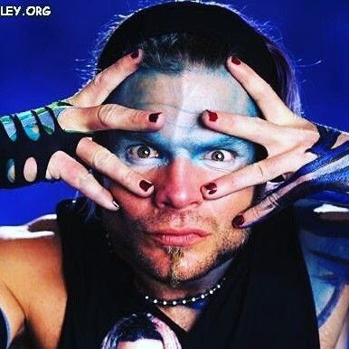 a man with his hands on his face and painted nails covering his eyes while posing for the camera