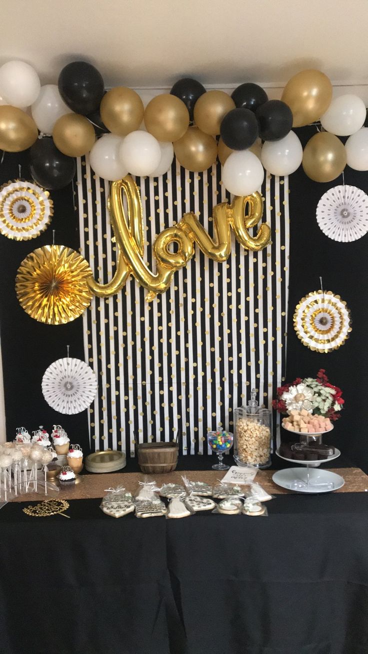 a table topped with lots of balloons and desserts