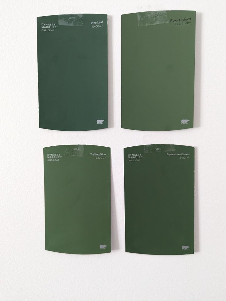 four pieces of green paint on a white wall