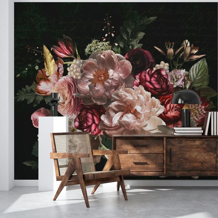 a room with flowers on the wall and a wooden chair in front of it,