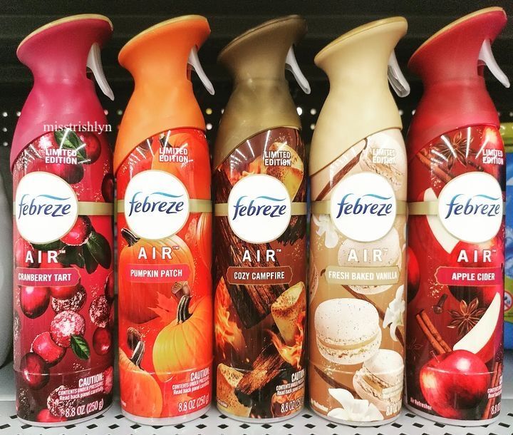 several bottles of air freshener are lined up on a shelf in a store aisle