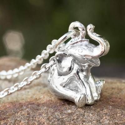 an elephant charm is sitting on top of a rock