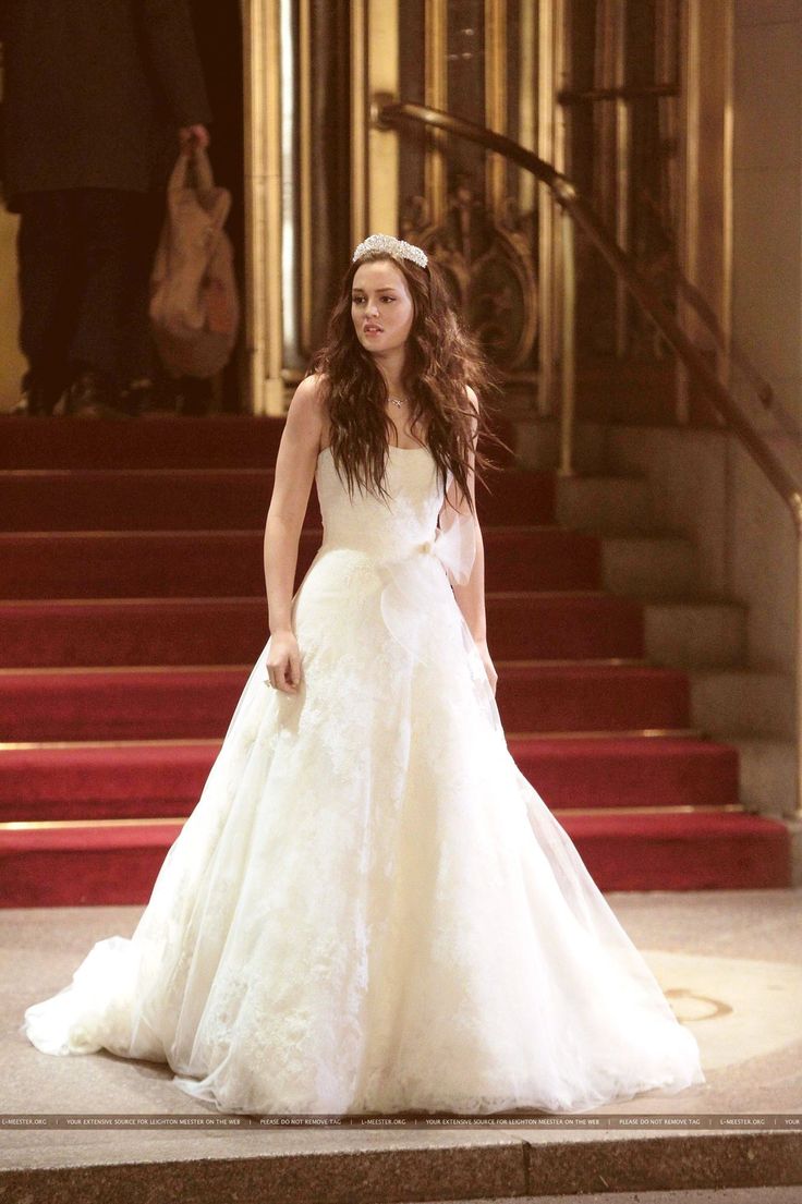 a woman in a wedding dress standing on steps