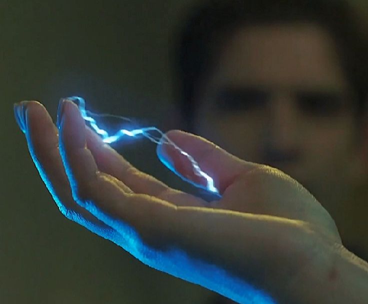 a man holding out his hand with a glowing lightening effect on it