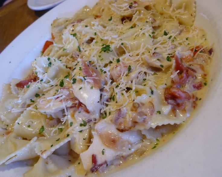 a white plate topped with pasta covered in cheese