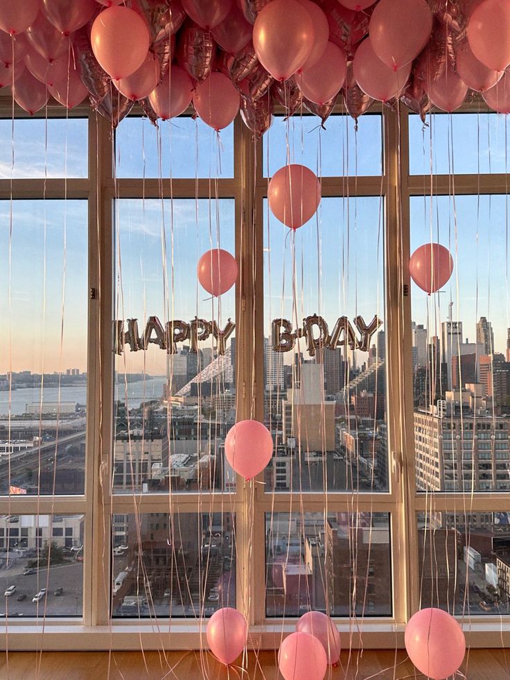 balloons and streamers are hanging in front of a window that reads happy bday