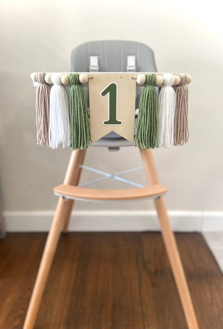 a wooden chair with tassels on it and a number one sign hanging from the back