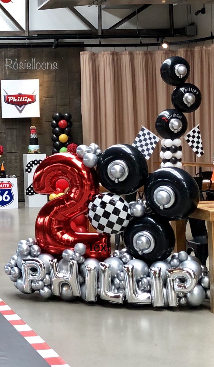 a birthday party with balloons and decorations in the shape of numbers, checkered table cloths