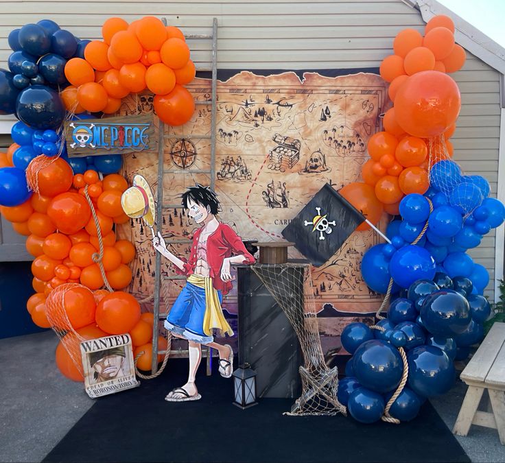 an outdoor stage set up with orange and blue balloons in the shape of pirate's chest