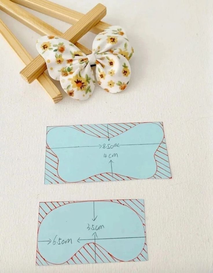 two pieces of paper with flowers on them next to wooden clothes pins