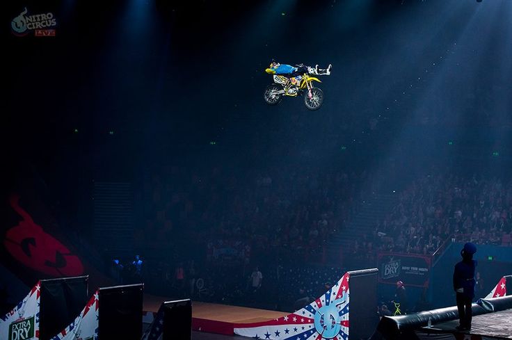 a man flying through the air while riding a motorcycle on top of a dirt bike