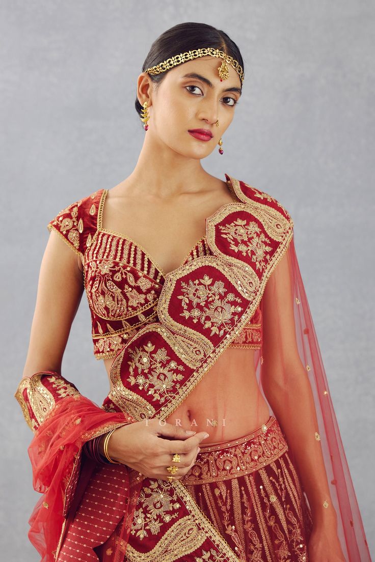 Bright red 12 kali lehenga in a silk velvet base gold thread and sequin embroidered motifs and cutwork detail at the border. Comes with sweetheart neckline blouse and butterfly net dupatta.
Component: 3
Pattern: Embroidery
Type Of Work: Thread and Sequin
Neckline: Sweetheart
Sleeve Type: Cap
Fabric: Silk Velvet and Butterfly Net
Color: Red
Other Details: 
Sheer dupatta with embroidered cutwork detail border
Scalloped lace trim on the blouse hems
Low back with tie up and tassels
Lehenga with tie Kali Lehenga, Sweetheart Neckline Blouse, Net Embroidery, Butterfly Net, Red Thread, Hem Blouse, Net Dupatta, Gold Threads, Red Silk