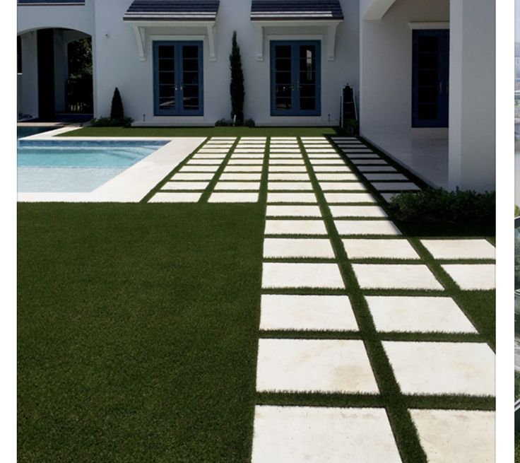 a large white house with a pool in the front yard and grass on the ground