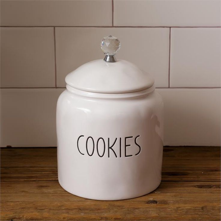 a white cookie jar sitting on top of a wooden table